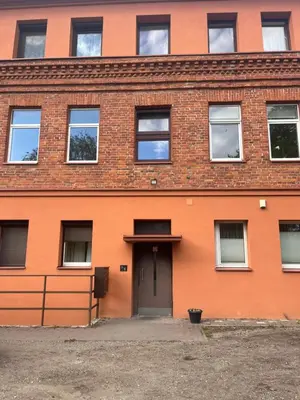 an orange brick building with a door at Nemunas Apartaments in Kaunas
