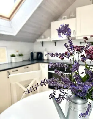 a vase filled with purple flowers sitting on a kitchen counter at #stayhere - Light Central 2 BDR Druskininkai apartment in Druskininkai