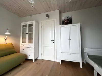 a room with white cabinets and a bed and a couch at #stayhere - Light Central 2 BDR Druskininkai apartment in Druskininkai