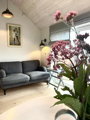 a living room with a couch and a table with flowers at #stayhere - Light Central 2 BDR Druskininkai apartment in Druskininkai
