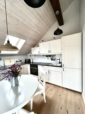 a kitchen with white cabinets and a white table and chairs at #stayhere - Light Central 2 BDR Druskininkai apartment in Druskininkai