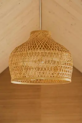 a wicker light fixture hanging from a ceiling at Sapnų cechas in Merkinė