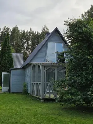 a house with a gambrel roof with a large window at Sodyba Upulupu