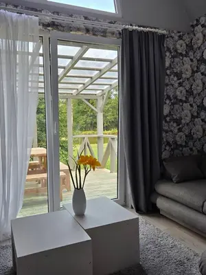 a living room with a vase of flowers on a table at Sodyba Upulupu