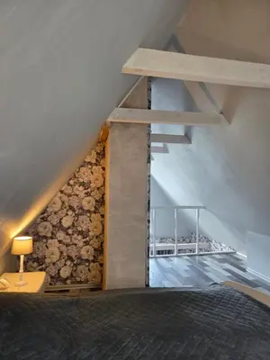 a bedroom with a stone wall and a bed at Sodyba Upulupu