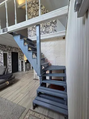 a staircase in a house with a blue stair case at Sodyba Upulupu