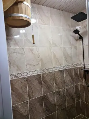a bathroom with a large tile shower with at Sodyba Pirtis Panarvė in Lazdijai