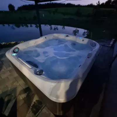 a bath tub with blue water in it at Sodyba Pirtis Panarvė in Lazdijai