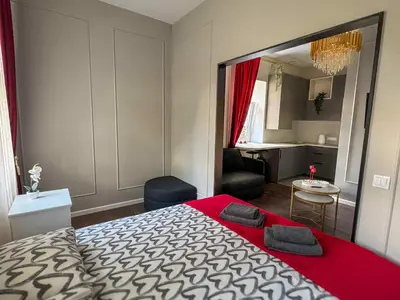 a bedroom with a large bed with a red blanket at Jacuzzi overlooking the tower in Vilnius