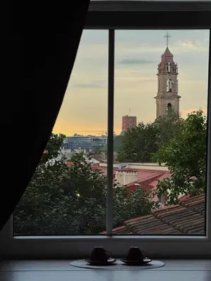 a window view of a city with a clock tower at Jacuzzi overlooking the tower in Vilnius