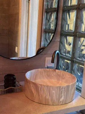 a sink in a bathroom with a large mirror at Jacuzzi overlooking the tower in Vilnius