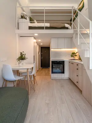 a kitchen and living room with a table and a bunk bed at Brand New Loft Naujamiestis in Vilnius