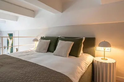 a bedroom with a bed with green and white pillows at Brand New Loft Naujamiestis in Vilnius