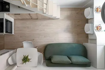 a living room with a green chair and stairs at Brand New Loft Naujamiestis in Vilnius
