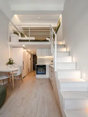 a living room with a staircase leading up to a loft at Brand New Loft Naujamiestis in Vilnius