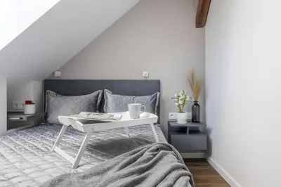 a bedroom with a white table on a bed at ALL SAINTS Residence in Vilnius