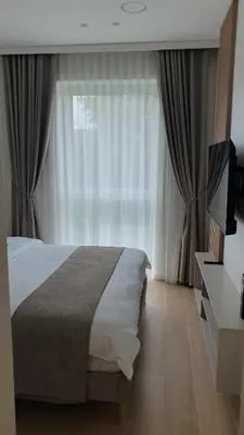 a bedroom with a bed and a large window at Cozy home night and day in Kaunas