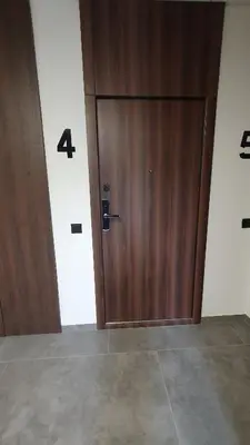 a wooden door in a room with the number four at Cozy home night and day in Kaunas