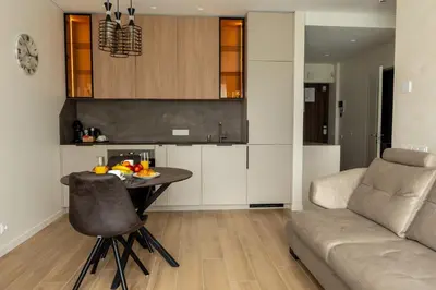 a kitchen and living room with a table and a couch at Cozy home night and day in Kaunas