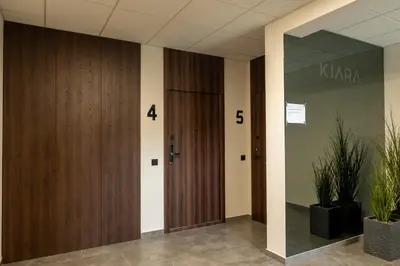 a hallway with wooden doors and potted plants at Cozy home night and day in Kaunas
