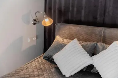a bed with two pillows on it with a lamp at Cozy Boho Loft in Vilnius