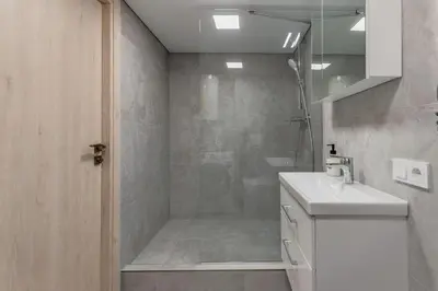 a bathroom with a shower with a sink and a toilet at Cozy Boho Loft in Vilnius
