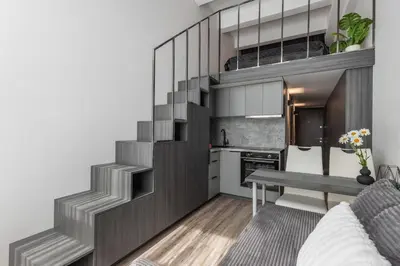 a small apartment with a staircase leading to a kitchen at Cozy Boho Loft in Vilnius