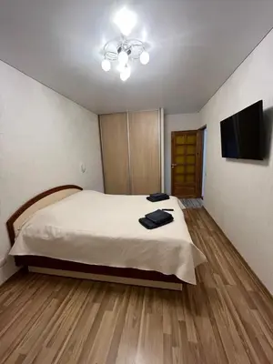 a bedroom with a bed and a flat screen tv at J&N Hause 2 in Visaginas