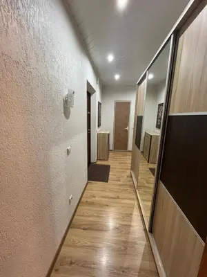 a hallway of a room with wooden floors and a mirror at J&N Hause 2 in Visaginas