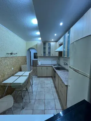 a kitchen with a table and a white refrigerator at J&N Hause 2 in Visaginas