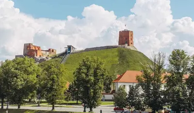 a castle on top of a hill with trees at Panorama Apartment Balcony Work Castle View in Vilnius