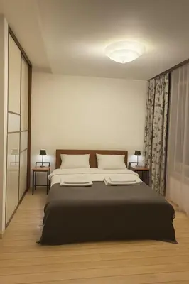 a bedroom with a large bed with a black blanket at Panorama Apartment Balcony Work Castle View in Vilnius