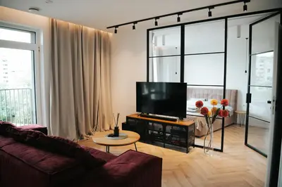 a living room with a couch and a flat screen tv at City Breeze Flat, Self Ceck-In, Free parking in Vilnius