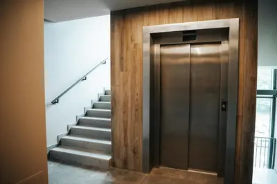 a metal elevator in a hallway with stairs at City Breeze Flat, Self Ceck-In, Free parking in Vilnius