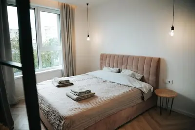 a bedroom with a bed with two towels on it at City Breeze Flat, Self Ceck-In, Free parking in Vilnius
