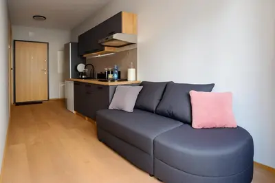 a living room with a blue couch and a kitchen at Zveryno City Appartments in Vilnius