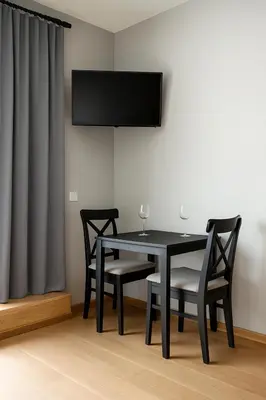 a black dining room table with two chairs and a television at Zveryno City Appartments in Vilnius