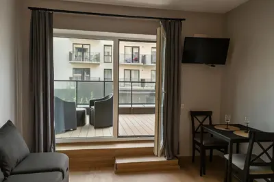 a living room with a sliding glass door to a balcony at Zveryno City Appartments in Vilnius