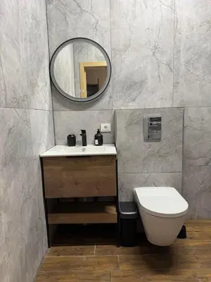 a bathroom with a sink and a toilet and a mirror at Zveryno City Appartments in Vilnius