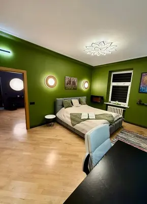 a bedroom with a bed and a green wall at Downtown Kaunas - Maironis 10 in Kaunas