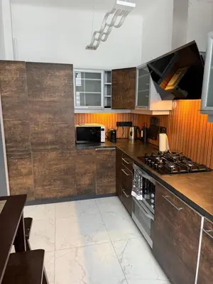 a kitchen with wooden cabinets and a stove top oven at Downtown Kaunas - Maironis 10 in Kaunas