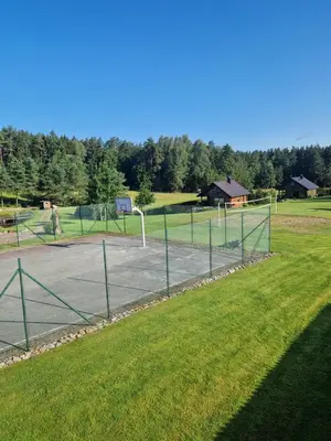a tennis court in a park with grass at VIP forest dreams villa 2 in Leliūnai