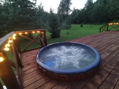 a hot tub on a wooden deck with lights at Skubėk Neskubėti in Klykiai