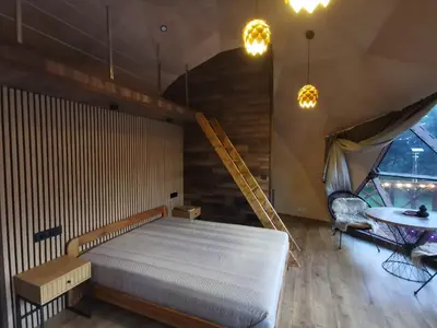 a bedroom with a large bed and a table at Skubėk Neskubėti in Klykiai