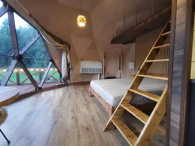 a bedroom in a tent with a bed and a ladder at Skubėk Neskubėti in Klykiai