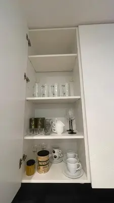 a cupboard filled with lots of cups and dishes at Central Kaunas Luxury Apartment with Free Parking in Kaunas