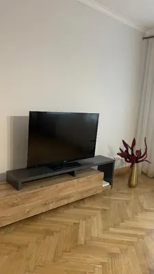 a flat screen tv sitting on top of a wooden entertainment center at Central Kaunas Luxury Apartment with Free Parking in Kaunas