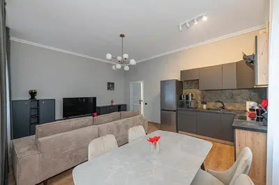 a living room and kitchen with a table and a couch at The Comfort Apartment #1 by Polo Apartments in Kaunas