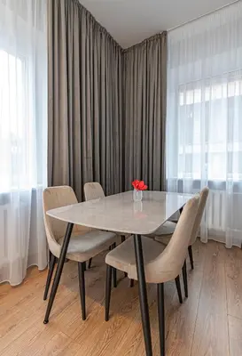 a dining room table with chairs and a vase on it at The Comfort Apartment #1 by Polo Apartments in Kaunas