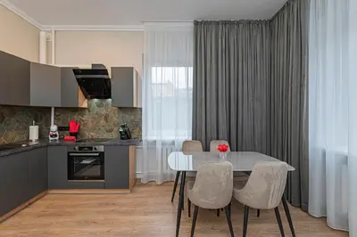 a kitchen with a table and chairs in a kitchen at The Comfort Apartment #1 by Polo Apartments in Kaunas